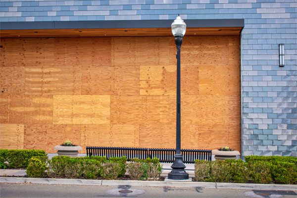 Exterior image of a business boarded up with plywood