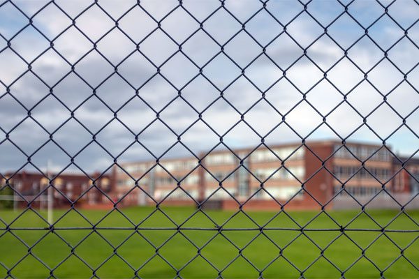 Photo of a school building behind a fence