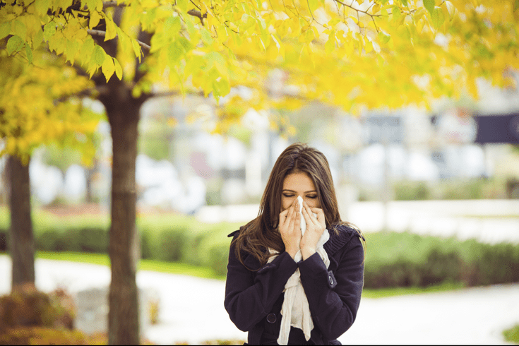 Woman outside blowing her nose