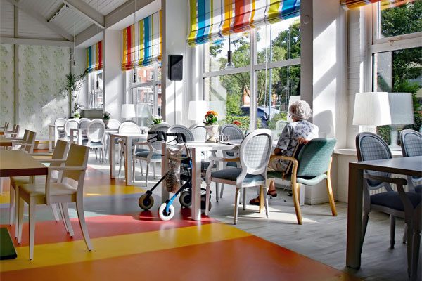 Photo of a senior in cafe of elderly home, used for M&A Trends in Health and Human Services blog post