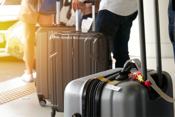 Photo of people wheeling their suitcases through a door