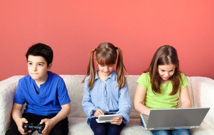 Three young kids playing video games