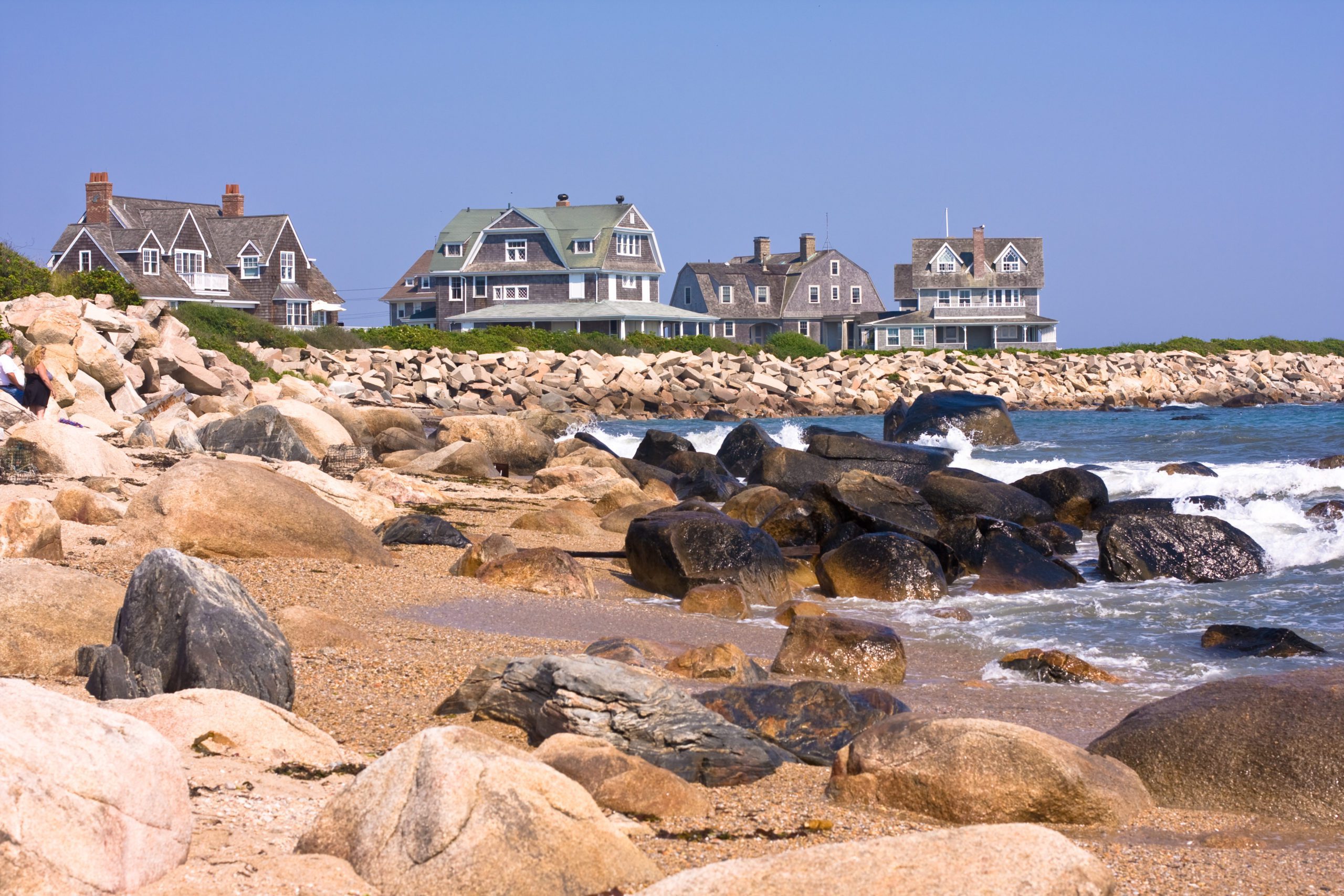 Zoomed out image of four beach houses overlooking the ocean