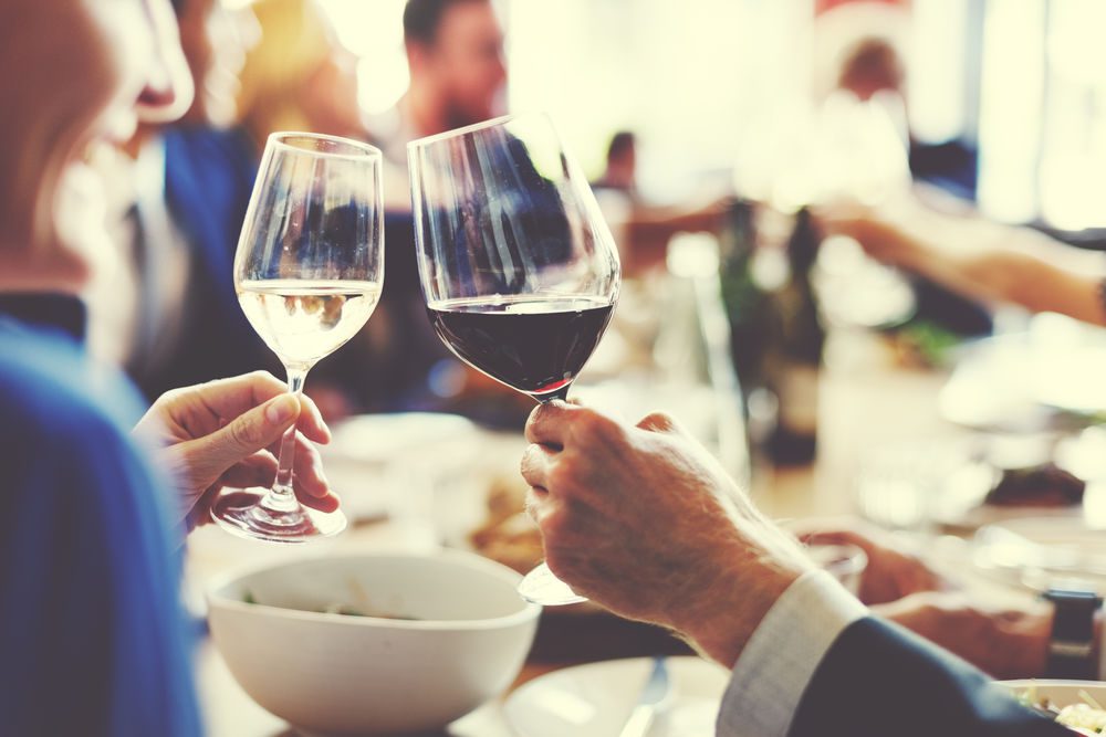 Close up of two people holding wine glasses