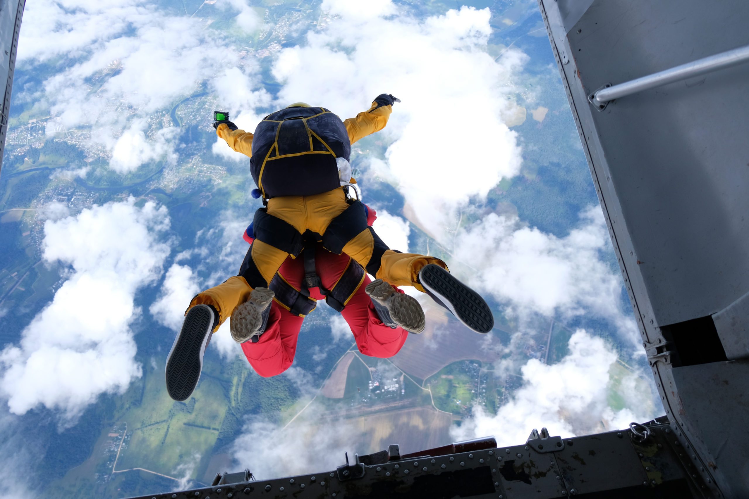 People skydiving with the clouds in the picture