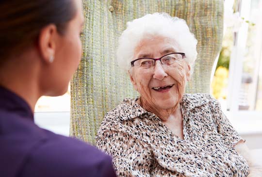 An old women smiling and looking to the side