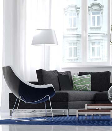 A grey couch and black chair with a white tall lamp in a modern room of a condo