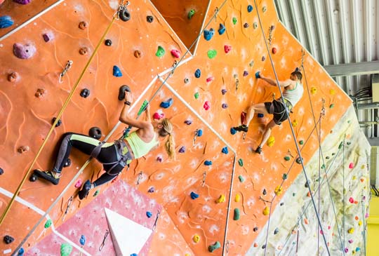 shutterstock_332856707 A woman and a man rock climbing