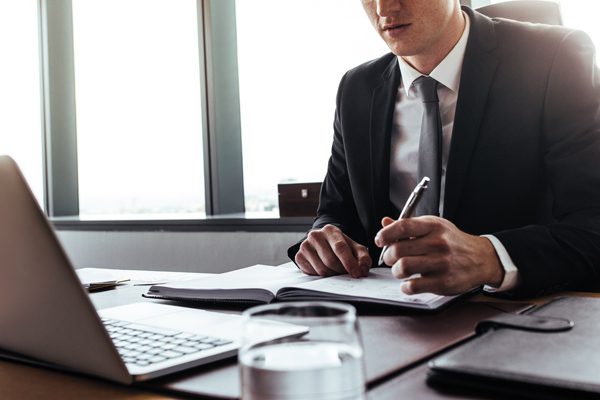 Photo of a business person at their desk with laptop in front of them